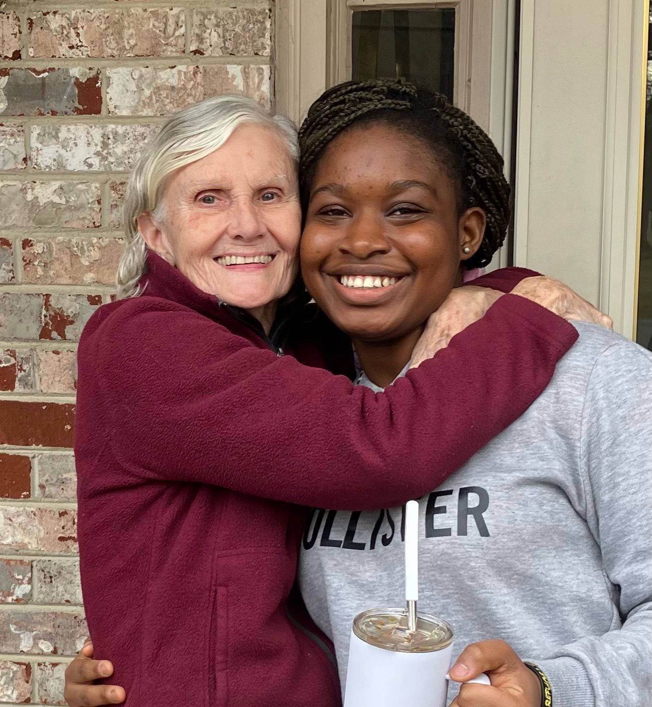 Two women sharing a warm embrace and smiling.